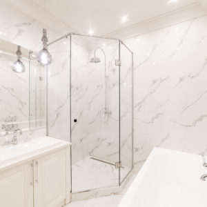 bright bathroom interior with white bath and shower